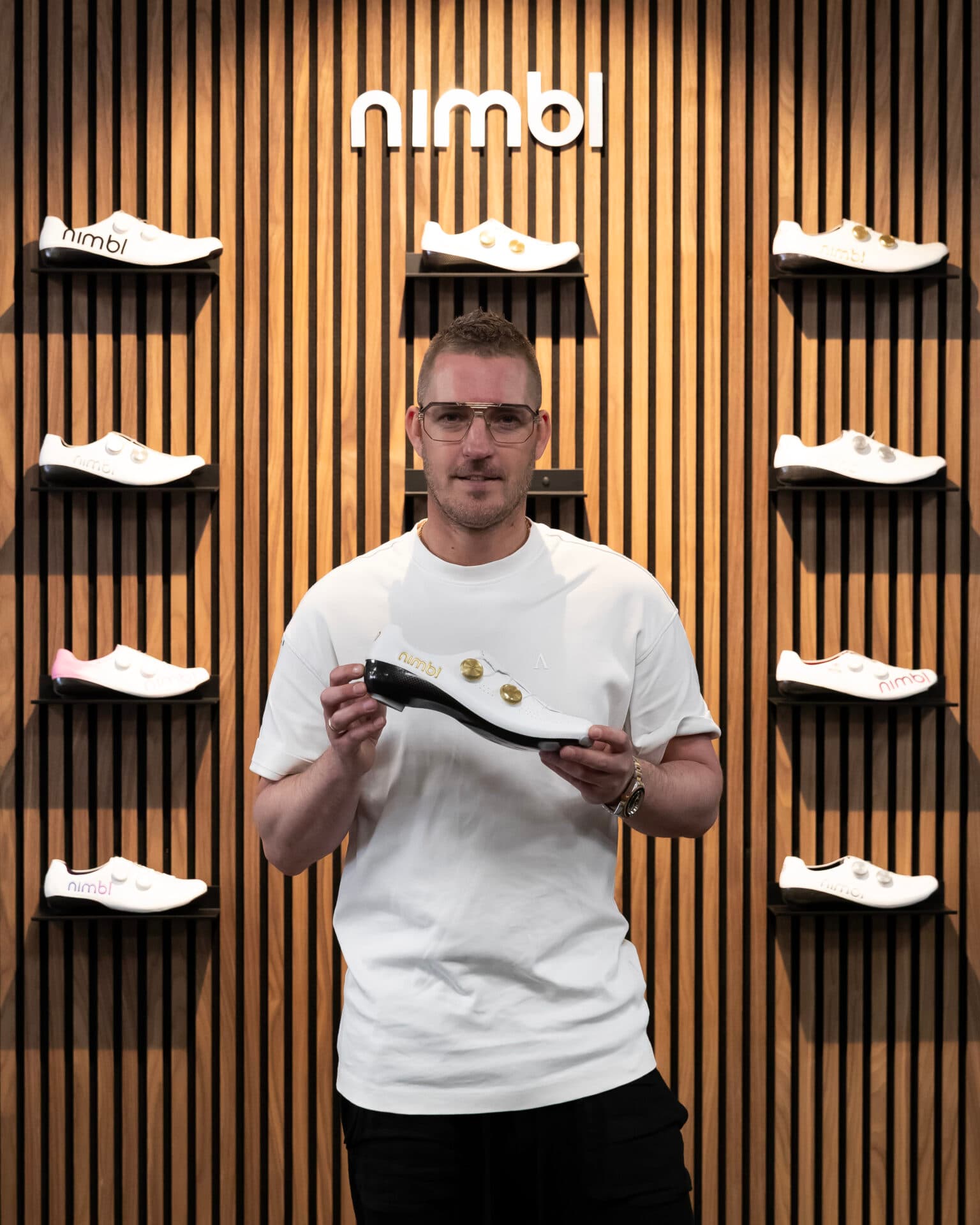 Ingmar Berga in de winkel bij de Nimbl-wand met wielrenschoenen